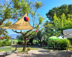 a yellow umbrella hanging from a tree in a yard at La Quercia in Altavilla Silentina