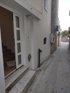 un callejón vacío con una puerta y escaleras en un edificio en Apartmani More, en Petrovac na Moru