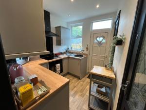 a small kitchen with a counter and a door at Contemporary & Chic inner terrace 5 mins from Barnsley town centre in Barnsley