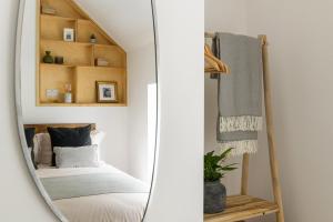 a mirror reflecting a bedroom with a bed in a room at Heathercliffe Cottage, Snowdonia National Park in Penmaen-mawr