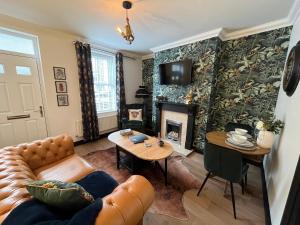 a living room with a couch and a fireplace at Contemporary & Chic inner terrace 5 mins from Barnsley town centre in Barnsley