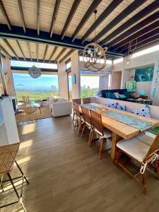 una sala de estar con una gran mesa de madera y sillas en Hermosa y acogedora parcela cerca de viñas y playa, en Algarrobo