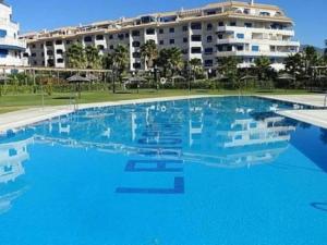 聖路易斯德薩比尼爾的住宿－Stunning Penthouse in San Luis de Sabinillas，大楼前的大型蓝色游泳池