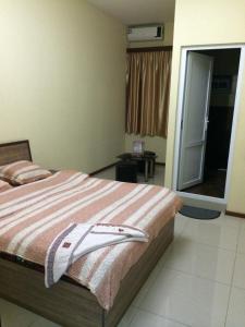 Un dormitorio con una cama con una toalla. en Star Hotel Didube en Tiflis