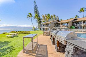 einen Grill und Picknicktisch neben einem Resort in der Unterkunft Polynesian Shores 118 in Kahana
