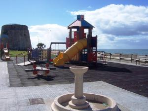 a playground with a slide in front of the ocean at Geminianum in Gemini