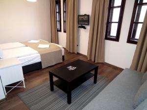 ヴェリコ・タルノヴォにあるWhite Houseのベッドとコーヒーテーブルが備わるホテルルームです。
