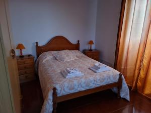 1 dormitorio con 1 cama con 2 toallas en Casa da Cruz, en Santa Cruz das Flores