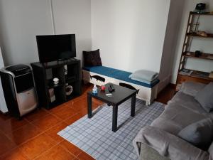 a living room with a couch and a table at Casa da Cruz in Santa Cruz das Flores