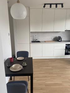 uma cozinha com armários brancos e uma mesa e cadeiras pretas em Urban Lifestyle em Viena