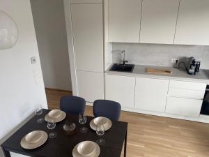 uma cozinha com mesa e cadeiras e uma cozinha com armários brancos em Urban Lifestyle em Viena