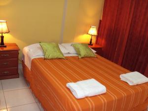 a bedroom with a bed with two towels on it at Nasca Lodge in Nazca