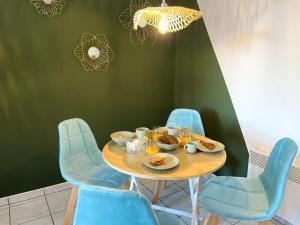 a dining room with a table with blue chairs at La Suite Frida, Cosy & Quiet in Beauvais