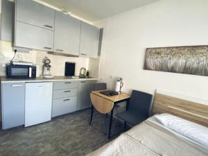 a room with a bed and a kitchen with a desk at Studio 20qm mit Balkon und Innenpool - 22031 in Schluchsee