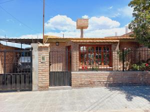 a brick house with a fence in front of it at Casa de Hugo in Cafayate