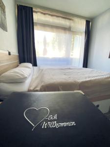 a bed with a sign on it with a heart on it at Studio 20qm mit Balkon und Innenpool - 22031 in Schluchsee