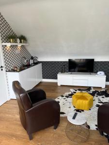 uma sala de estar com uma cadeira e uma televisão em Rooftop terrace suite em Heist-op-den-Berg