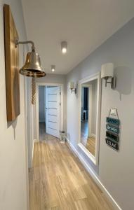 Apartment Premium Wood Baltic Park - 58m2, 3 pokoje في ستيغنا: غرفة مع مدخل مع أرضيات خشبية وأثاث خفيف