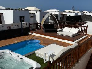 a deck with a hot tub on a balcony at Villa 64, Vista Lobos, private heated pool x jacuzzi, Playa Blanca in Playa Blanca