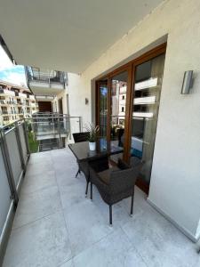 a patio with a table and chairs on a balcony at Apartment Premium Wood Baltic Park - 58m2, 3 pokoje in Stegna