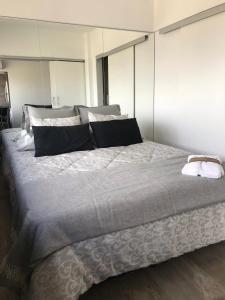een slaapkamer met een groot bed met zwart-witte kussens bij Esmeralda in Buenos Aires
