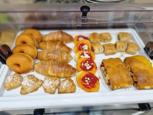 una bandeja llena de diferentes tipos de donuts y bollería en B&B La Veduta en Nápoles