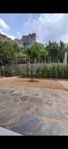 a park with a stone floor with a mountain in the background at Panos Luxury Suites in Kalabaka