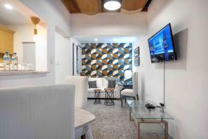 a living room with a couch and a tv on a wall at Escape 2BR Apartment in Gazcue Close to Colonial Zone in Santo Domingo