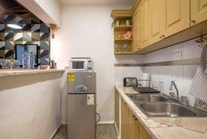 a small kitchen with a sink and a refrigerator at Escape 2BR Apartment in Gazcue Close to Colonial Zone in Santo Domingo +25 photos