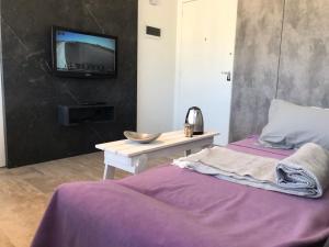 een slaapkamer met een bed en een tv aan de muur bij Esmeralda in Buenos Aires