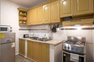 a kitchen with yellow cabinets and a sink and a stove at Escape Apartment in Gazcue Close to Colonial Zone in Santo Domingo