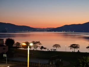a view of a lake at sunset with a street light at Apartamentos arcade in Arcade