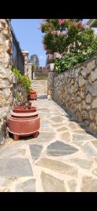 a stone walkway with a stone wall and two benches at Panos Luxury Suites in Kalabaka