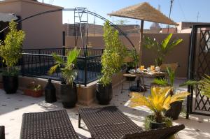 een patio met tafels en stoelen en potplanten bij RIAD N° 16 in Marrakesh