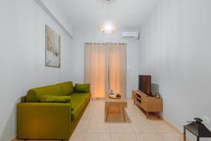 salon z zieloną kanapą i telewizorem w obiekcie THALASSA ALMYROS APARTMENTS w mieście Almirón