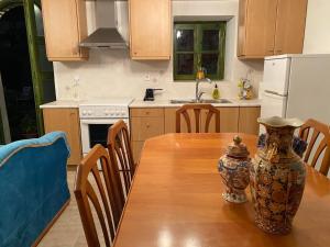 uma cozinha com uma mesa de madeira com um vaso sobre ela em Petra Maisonettes em Kariá