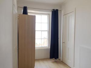 una puerta abierta en una habitación con ventana en Beautiful 2 Bed Serviced Apartment in Dunbar, en Dunbar