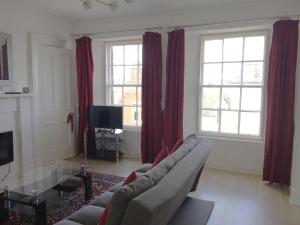 uma sala de estar com um sofá e duas janelas em Beautiful 2 Bed Serviced Apartment in Dunbar em Dunbar
