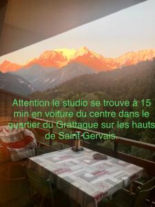 uma pintura de montanhas numa parede com uma mesa em Studio Turquoise quartier Grattague vue MontBlanc em Saint-Gervais-les-Bains
