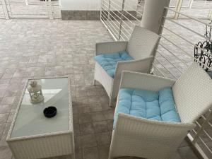 patio z krzesłami i stołem z niebieską poduszką w obiekcie Aury & Ester Casa Vacanze w mieście Crema