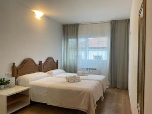 1 dormitorio con 2 camas y ventana en ARZUAWAY, en Arzúa
