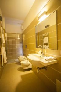 uma casa de banho com 2 lavatórios, um WC e um espelho. em Agriturismo Le Volpi em Baone