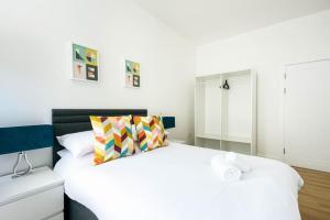 a white bedroom with a large white bed and a mirror at Lovely 2 bedroom apartment in Central Bristol in Bristol