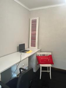 una oficina con un escritorio con una bolsa roja en una silla en Brisas del Lago Tandil en Tandil