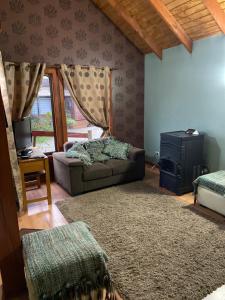 a living room with a couch and a tv at Cabañas El Galo in Panguipulli