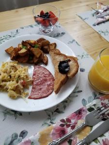 a plate of breakfast food with meat toast and bread at Hill Road Manor Bed & Breakfast in Grand Falls -Windsor