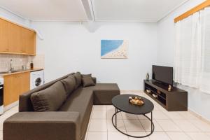 a living room with a couch and a table at THALASSA ALMYROS APARTMENTS in Almirón