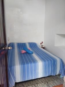 a blue and white bed with two pillows on it at Cabaña 52 en la Aldea Doradal Santorini Colombiano in Doradal