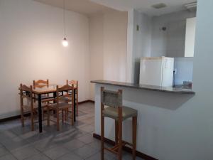 uma cozinha com uma mesa e cadeiras e um frigorífico em Acomodação Cecília. em Campos dos Goytacazes