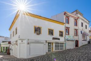 ein weißes Gebäude mit zwei Garagentüren auf einer Straße in der Unterkunft Townhouse N7 - Albufeira in Albufeira